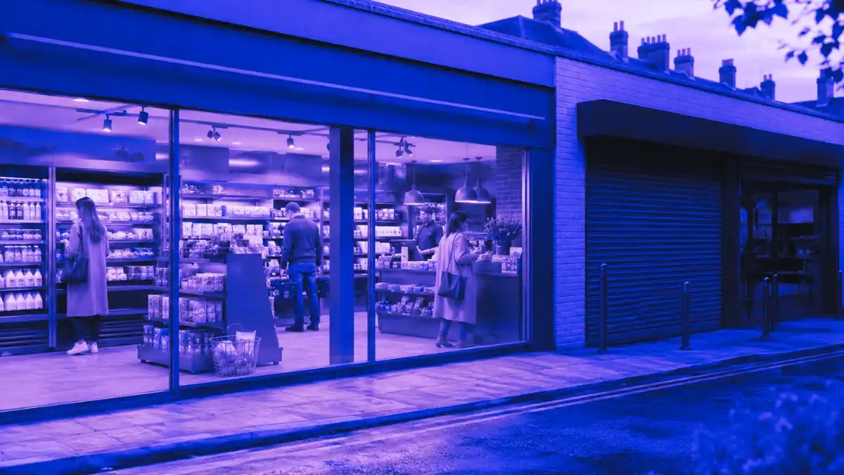 A modern UK convenience store with shoppers inside beside a closed storefront, showing how Morrisons store closures reflect rising retail cost pressure despite sales growth.